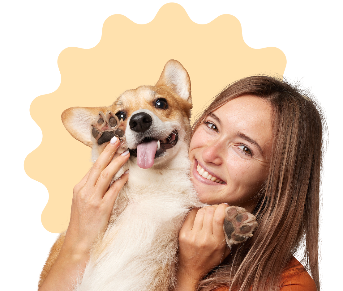 Smiling woman holding a happy corgi